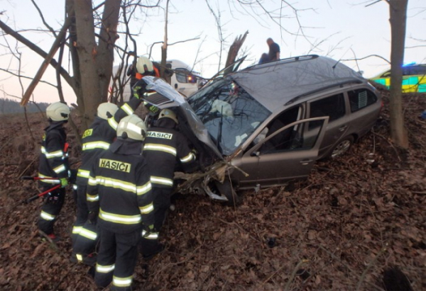 Vůz skončil po nehodě zaklíněn mezi stromy